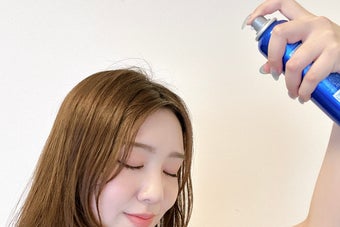 女性がスプレー缶を使っている様子。