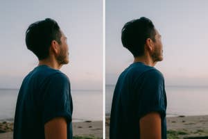 A person with short dark hair stands on a beach, looking at the horizon. They wear a casual short-sleeved shirt, enjoying a peaceful moment